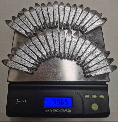 Rivernsea 34 piece pack of 5oz lead snapper fishing sinkers with eyelets, displayed on a digital scale.