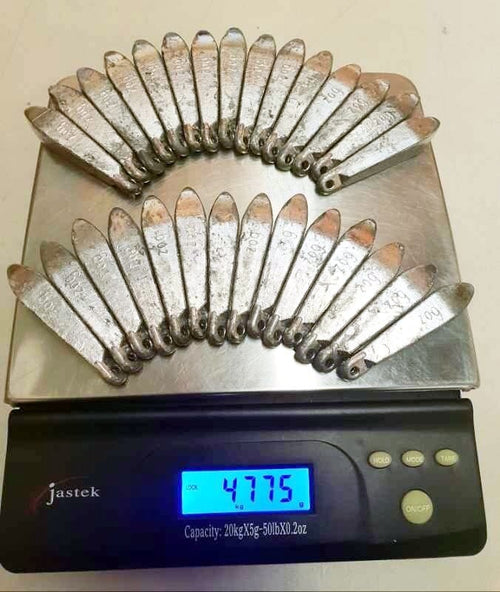 Rivernsea 28 pack of 6oz lead snapper fishing sinkers with smooth finish and eyelets displayed on a digital scale
