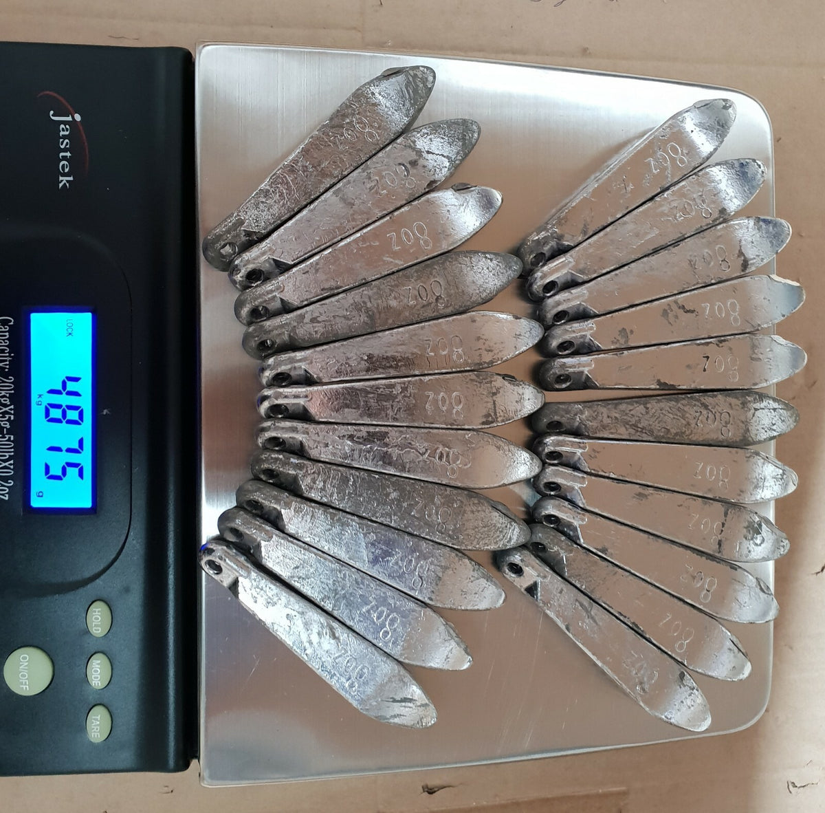 Rivernsea 21 piece pack of 8oz lead snapper fishing sinkers with eyelets arranged on a digital scale